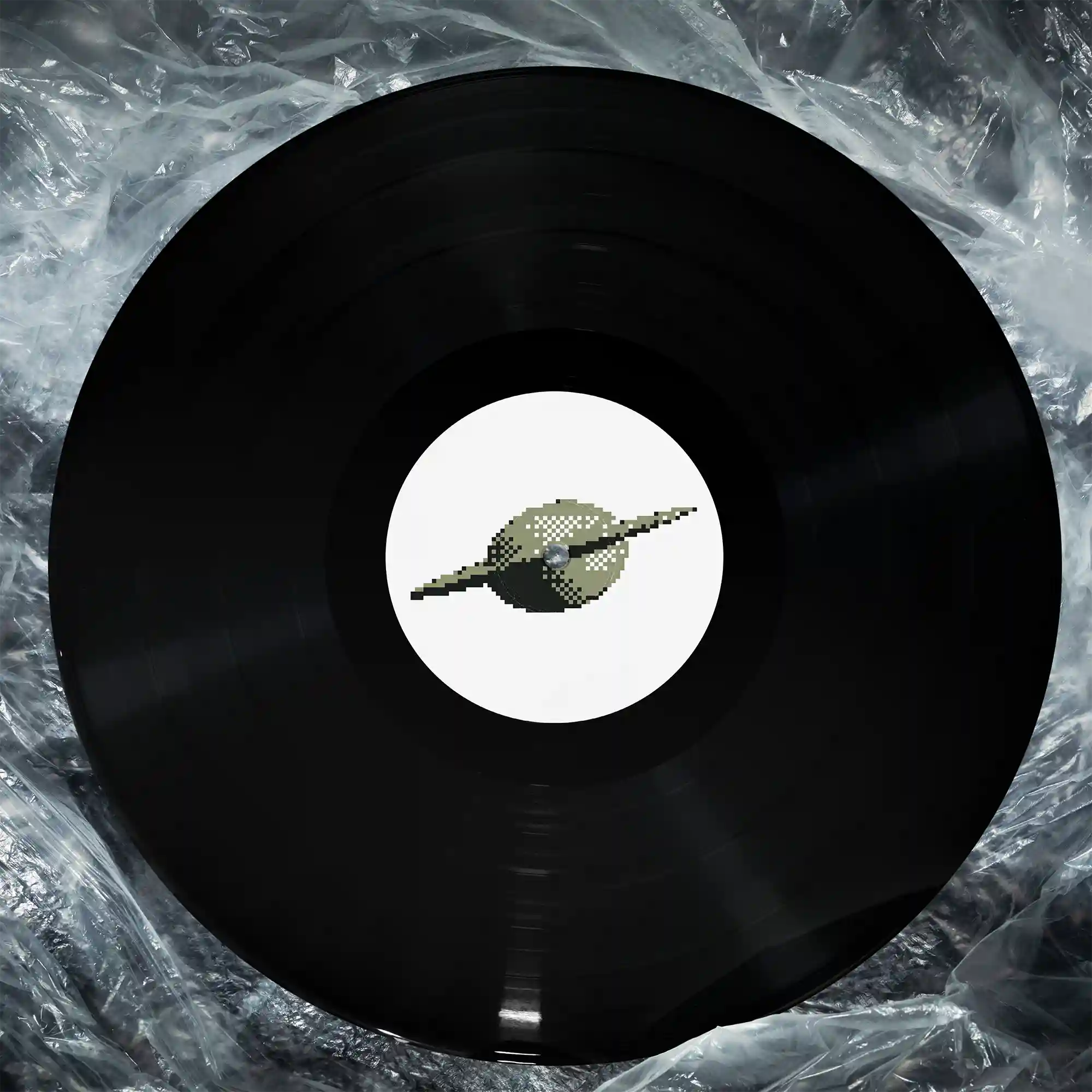 Schwarze Vinyl-Schallplatte auf zerknitterter Klarsichtfolie. Das weiße Label in der Mitte zeigt eine pixelierte, retro-stilisierte Darstellung eines UFOs (fliegende Untertasse) im 8-Bit-Look in Grün- und Grautönen.
